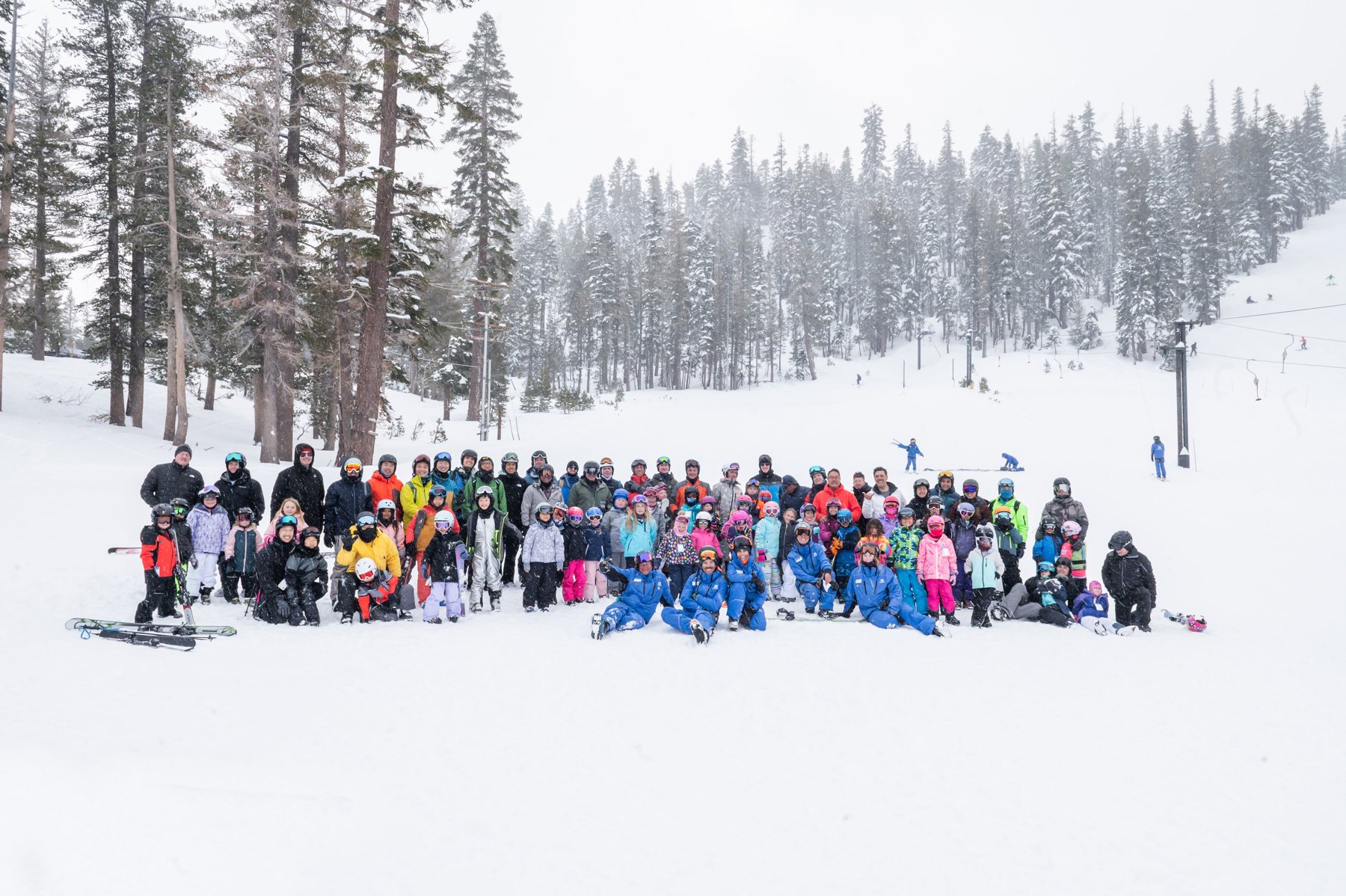 Dads and children gather in falling snow at Mammoth