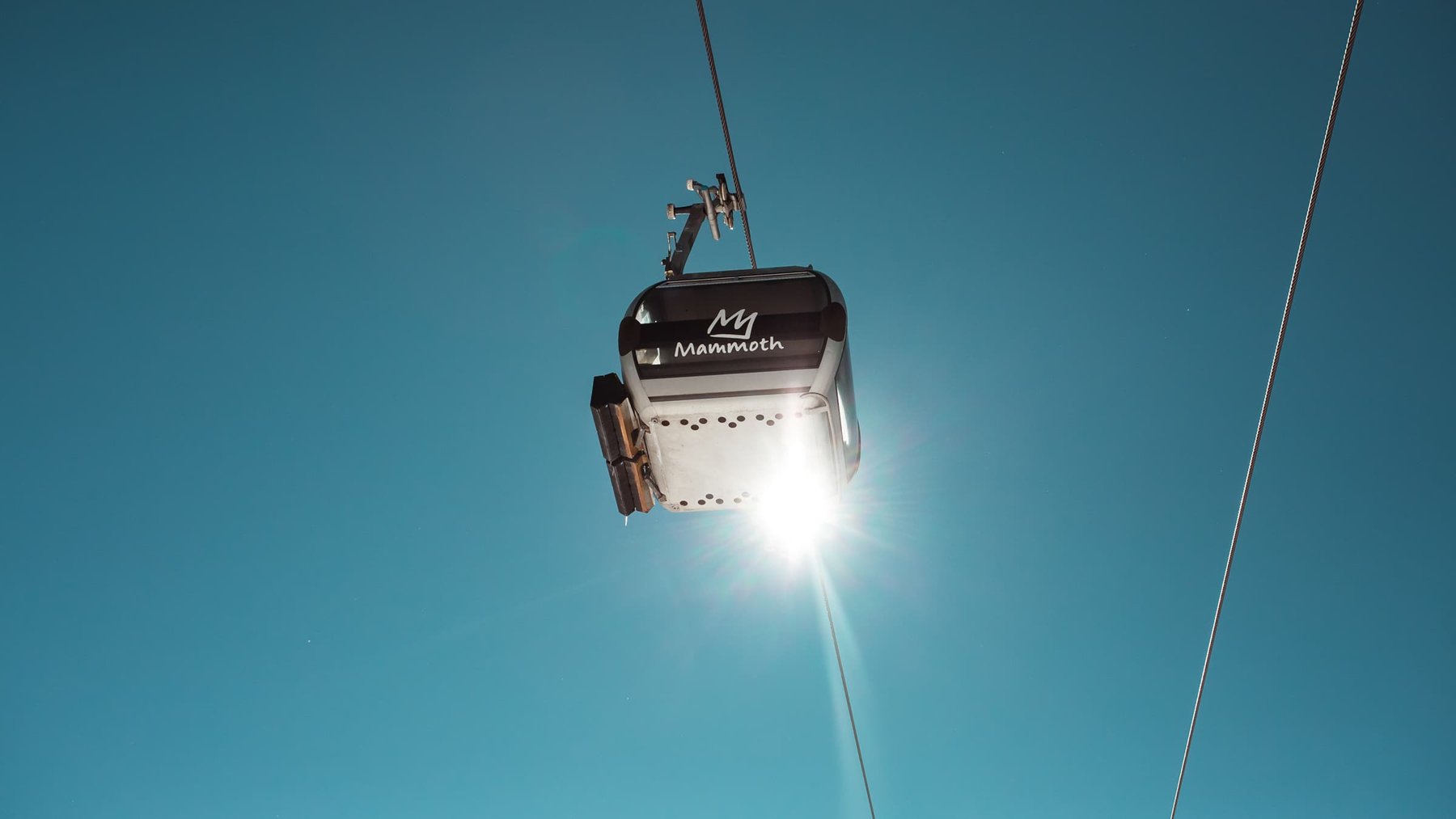 A gondola at Mammoth Mountain against a blue winter sky